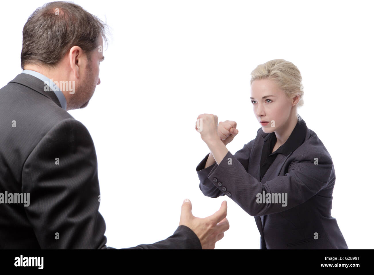Studio shot of two co-workers wearing suits, fighting in the office, isolated on a white background. Stock Photo