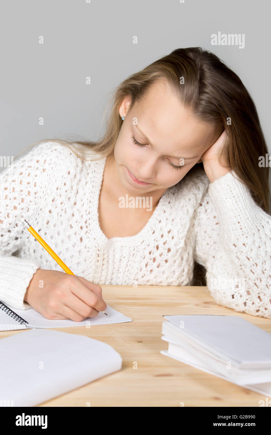 Portrait of stressed beautiful casual girl, sitting at desk, holding her head in arms with overwhelmed frustrated expression Stock Photo