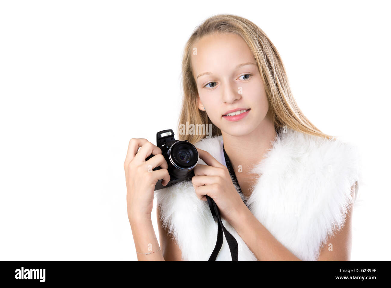 Portrait of happy cute beautiful blond girl wearing white furry outfit, holding digital camera with thoughtful expression Stock Photo