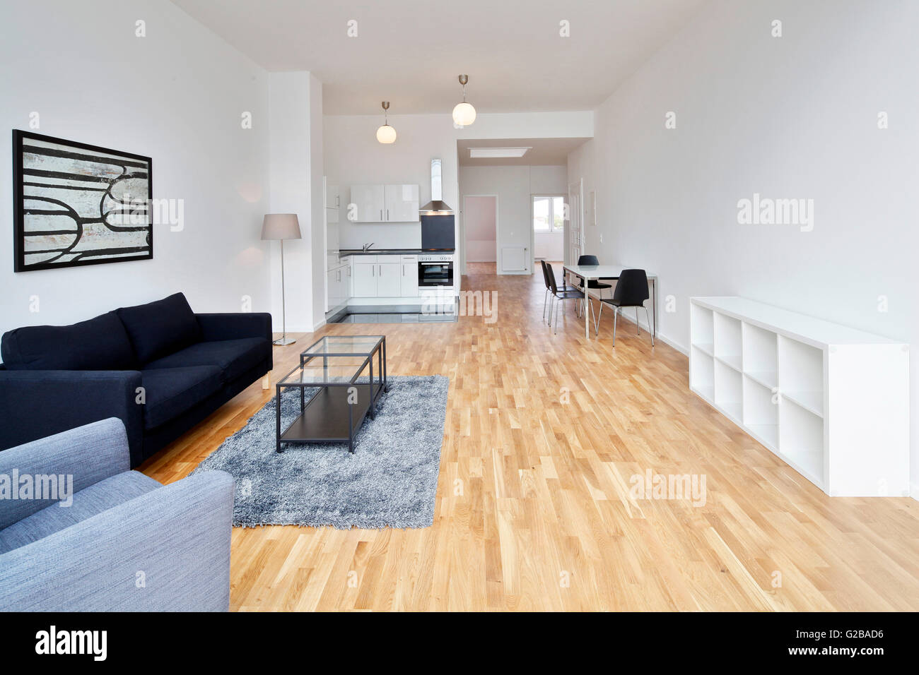 Conversion of Dach or Loft Space in Reichenberger Strasse, Kreuzberg. Open plan loft living. View of a modern living area and kitchen with modern dining table. Wood floors and white walls. Minimal decoration. Stock Photo