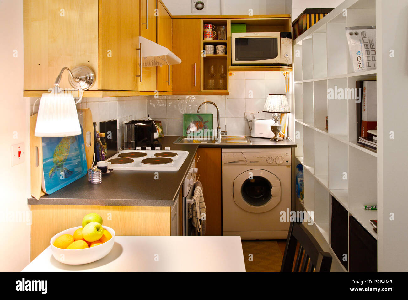 Pembridge Square, Notting Hill. Cramped traditional kitchen with washer and shelving units. Stock Photo
