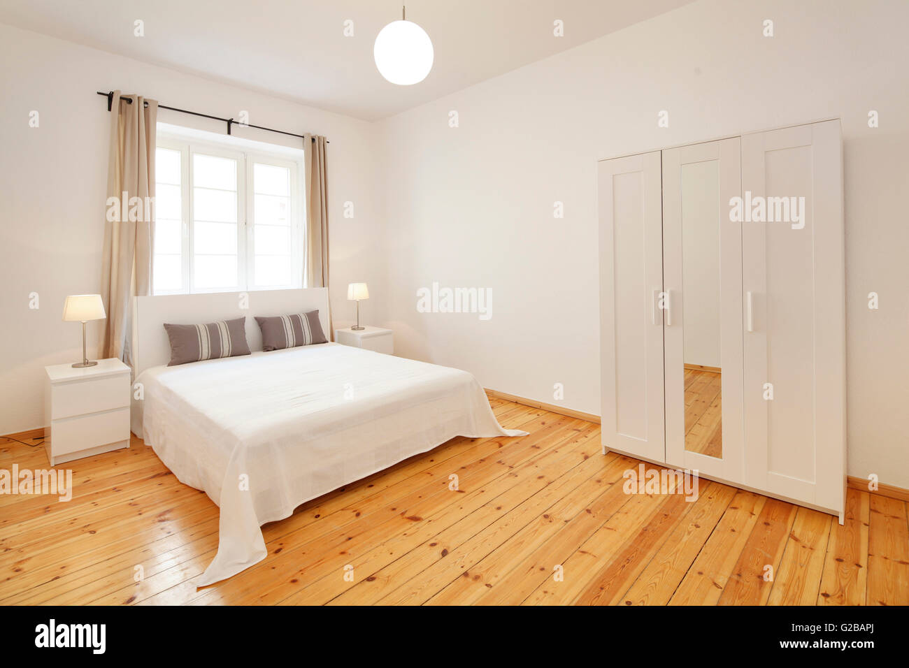 Wisbyer Strasse 59. Modern, minimal bedroom with neutral tones and large window. Stock Photo
