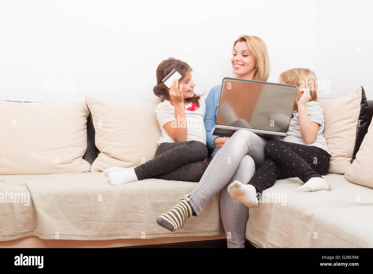 Mother and young daughters shopping online concept using laptop and credit card Stock Photo
