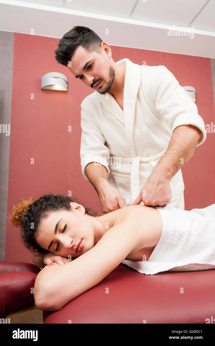 Young male masseur giving a back massage to attractive woman in the spa as  therapy concept Stock Photo - Alamy