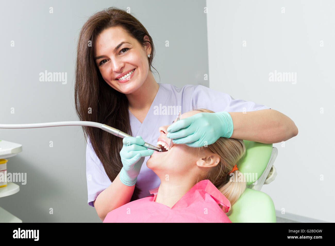 Friendly Female Dentist Drilling Patient Tooth As Orthodontic Procedure ...