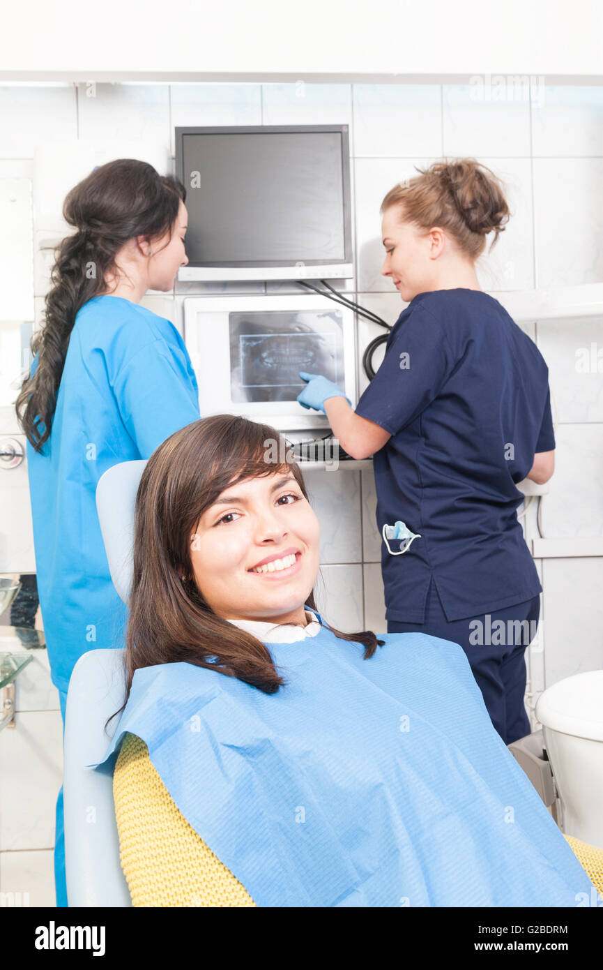 Female dentist and assistant analyzing dental xray plate at the dental