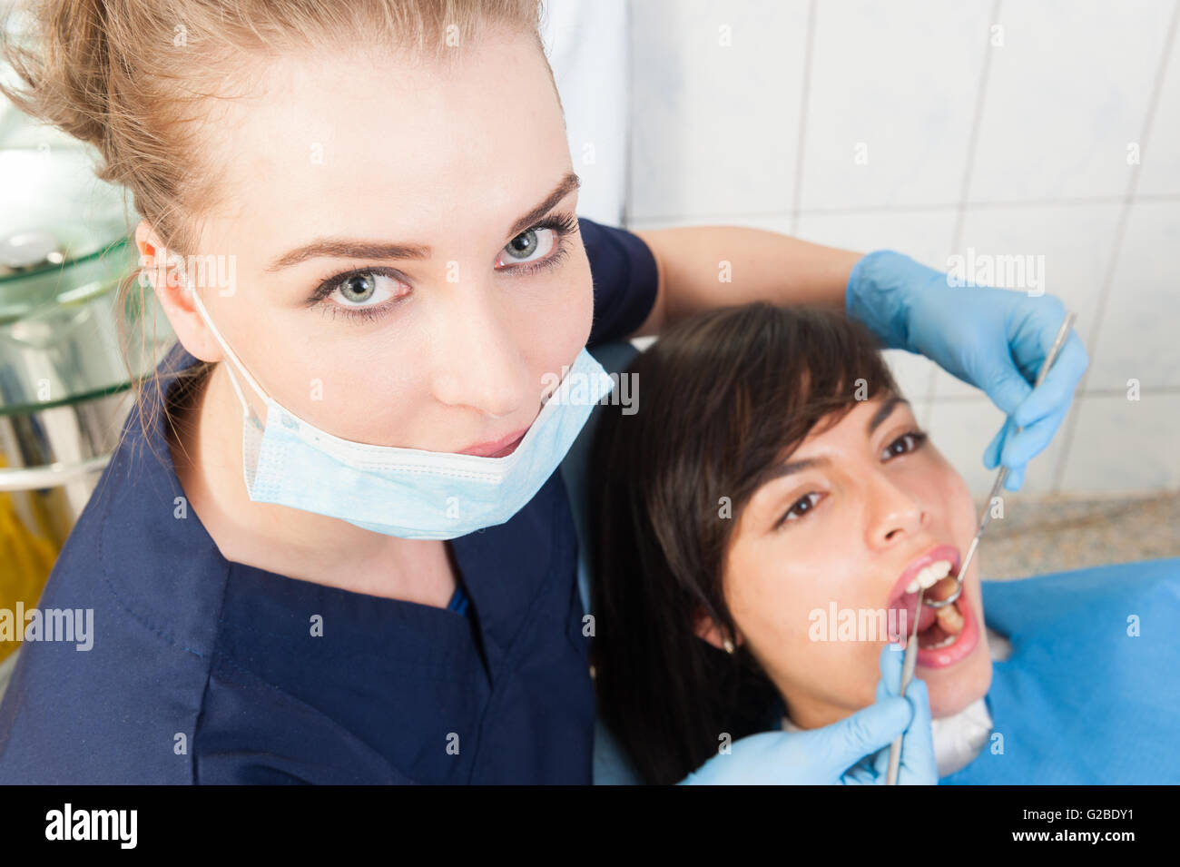 Beautiful woman dentist examining female patient teeth with dental ...