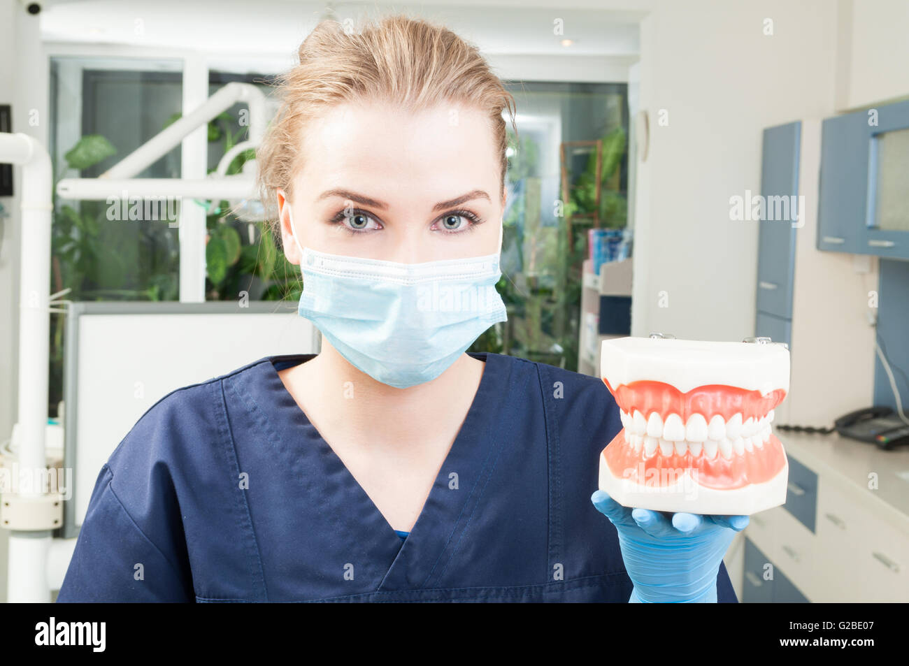 Portrait of beautiful female dentist wearing mask and uniform and