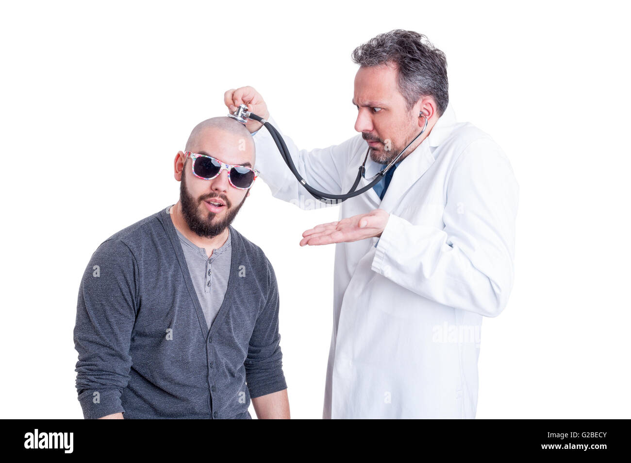 Young doctor checking a silly patient with head problem to establish a diagnostic on white studio background Stock Photo