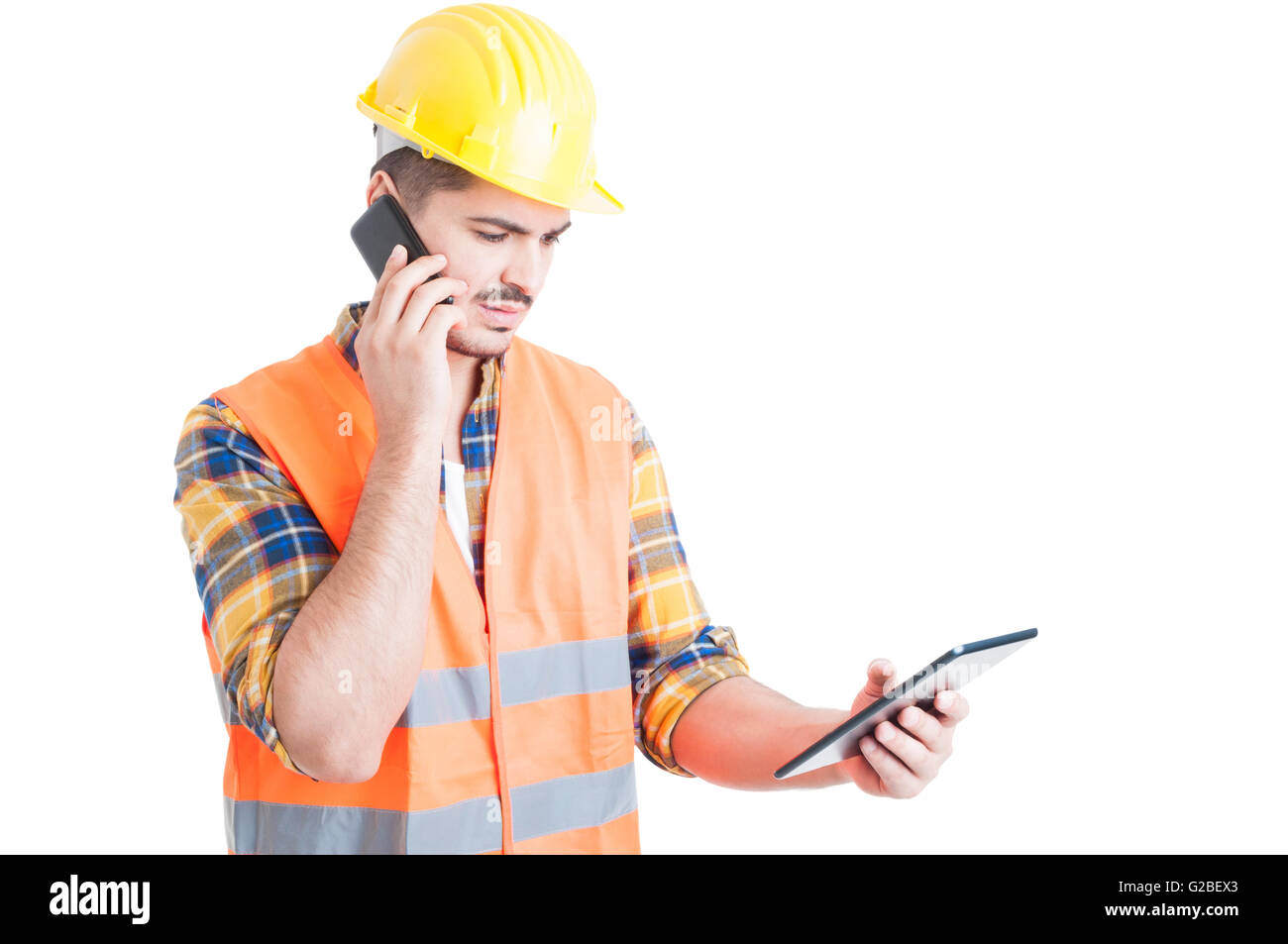 Multitasking concept with young constructor holding a tablet and use a ...