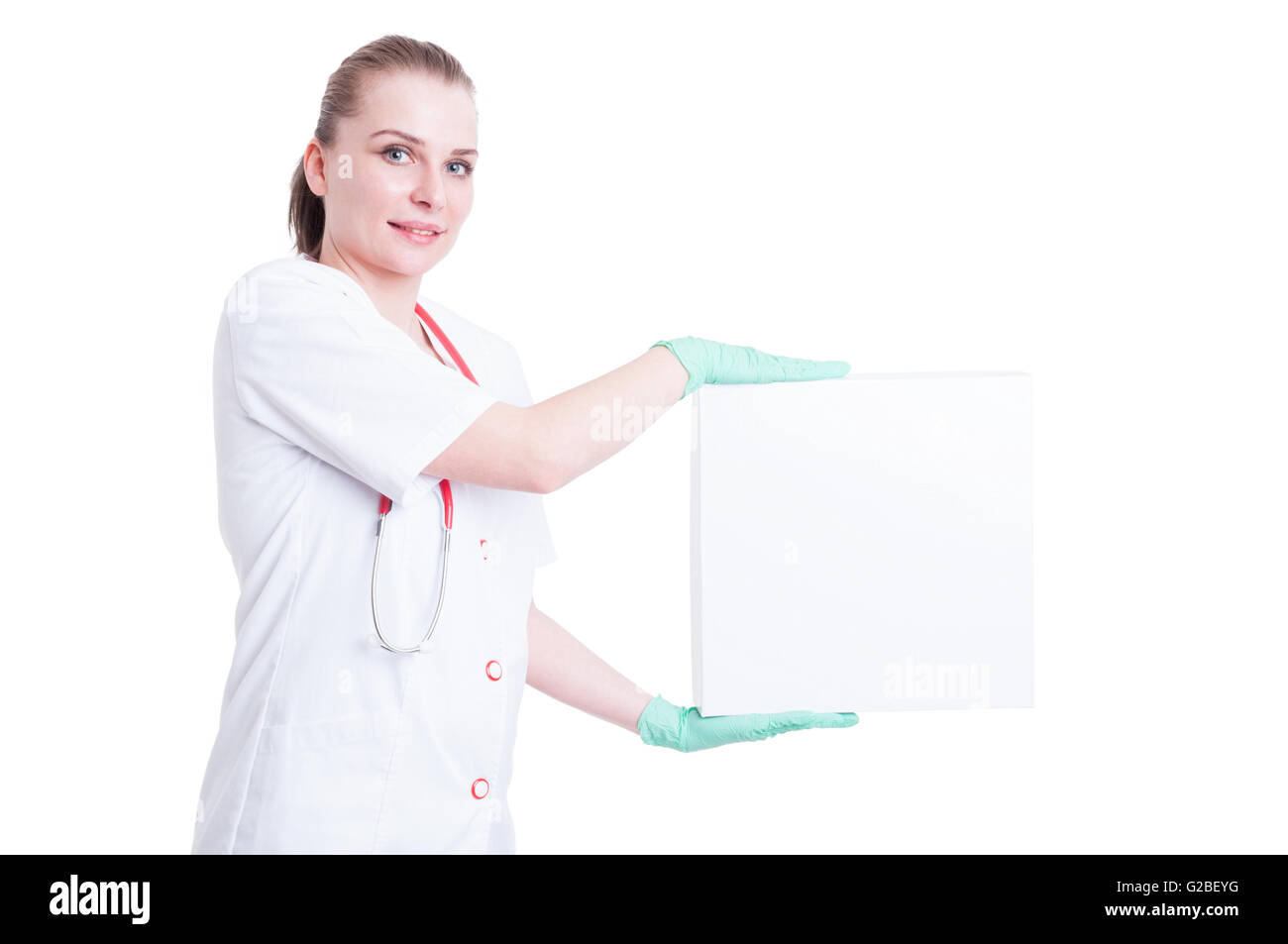 Attractive woman doctor smiling with a big box on her hands with advertising area isolated on white Stock Photo