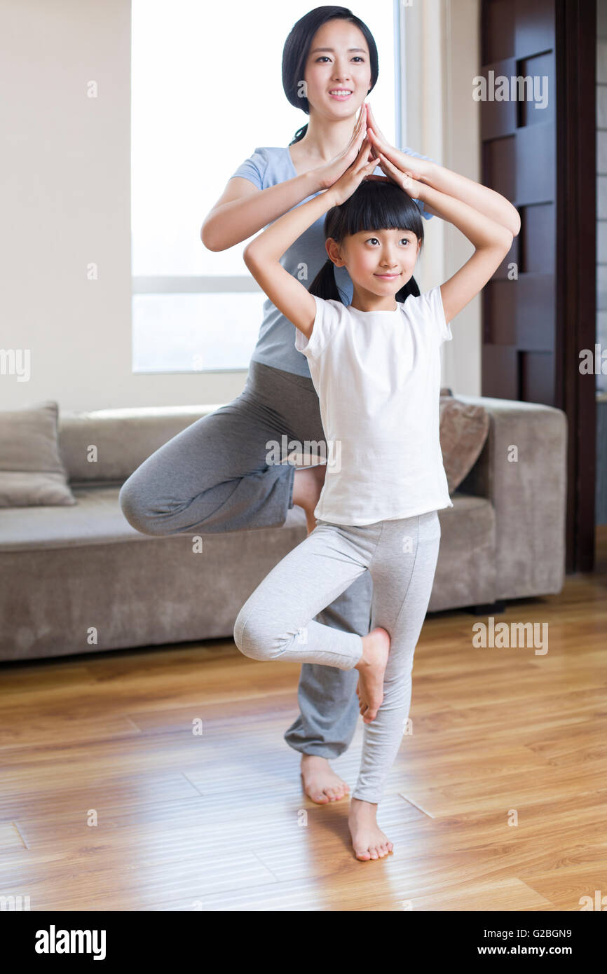 Young mother and daughter doing yoga at home Stock Photo - Alamy