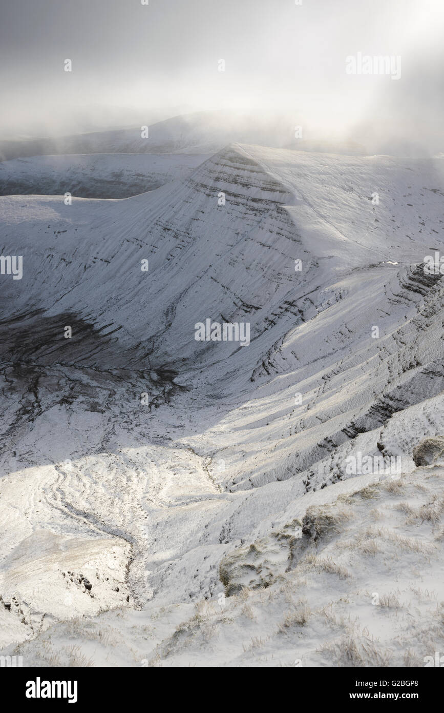 Snow covered Cribyn in the Brecon Beacons, illuminated by a break in the clouds. Stock Photo