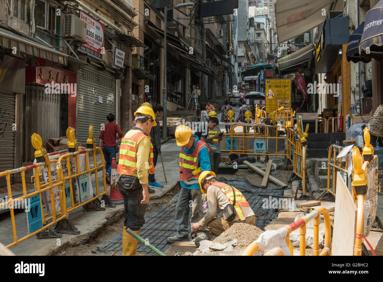 City workers involved in street construction repair, Hong Kong Stock Photo