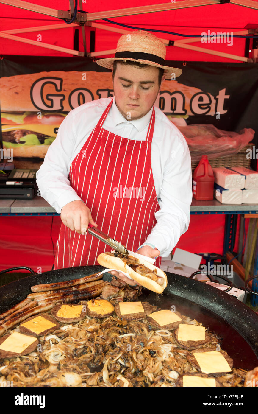 Man serving hot dog and sausages at a food stand at a country show UK