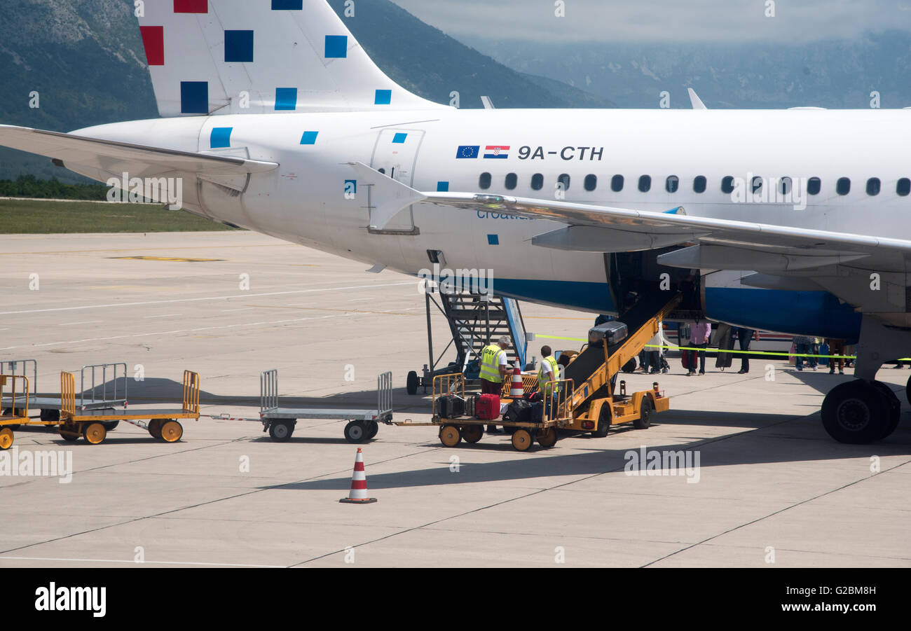 DUBROVNIK INTERNATIONAL AIRPORT COATIA   A Croatia Airlines jet on the apron with baggage handlers loading the aircraft hold Stock Photo