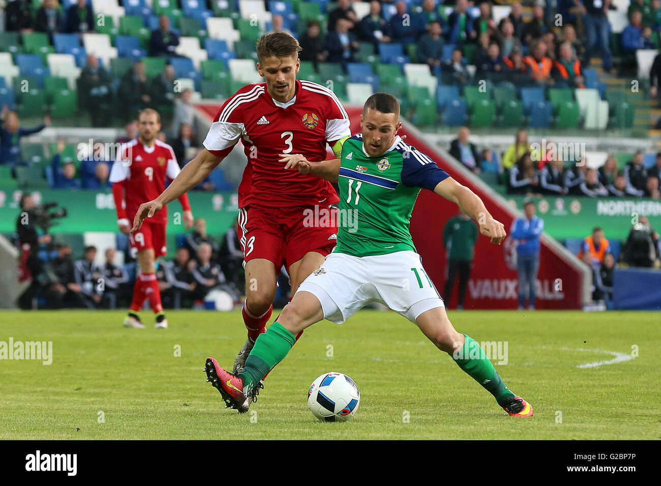 Northern Ireland's Conor Washington (right) and Belarus' Aleksandr Martynovich in action during the International Friendly at Windsor Park, Belfast. Stock Photo