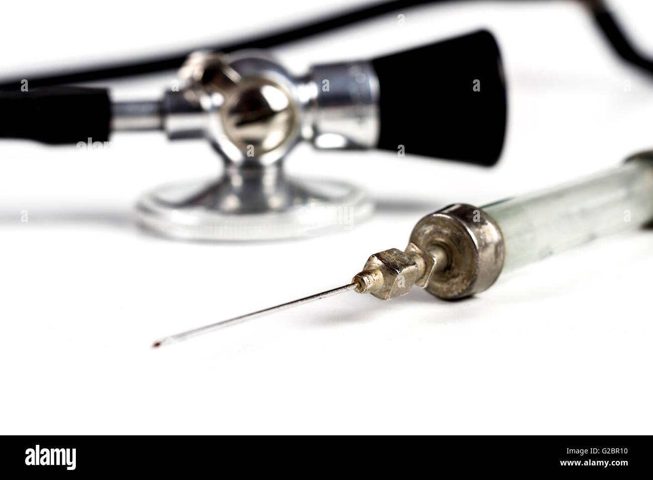 Glass Syringe With Black Old Stethoscope on White Background Stock Photo