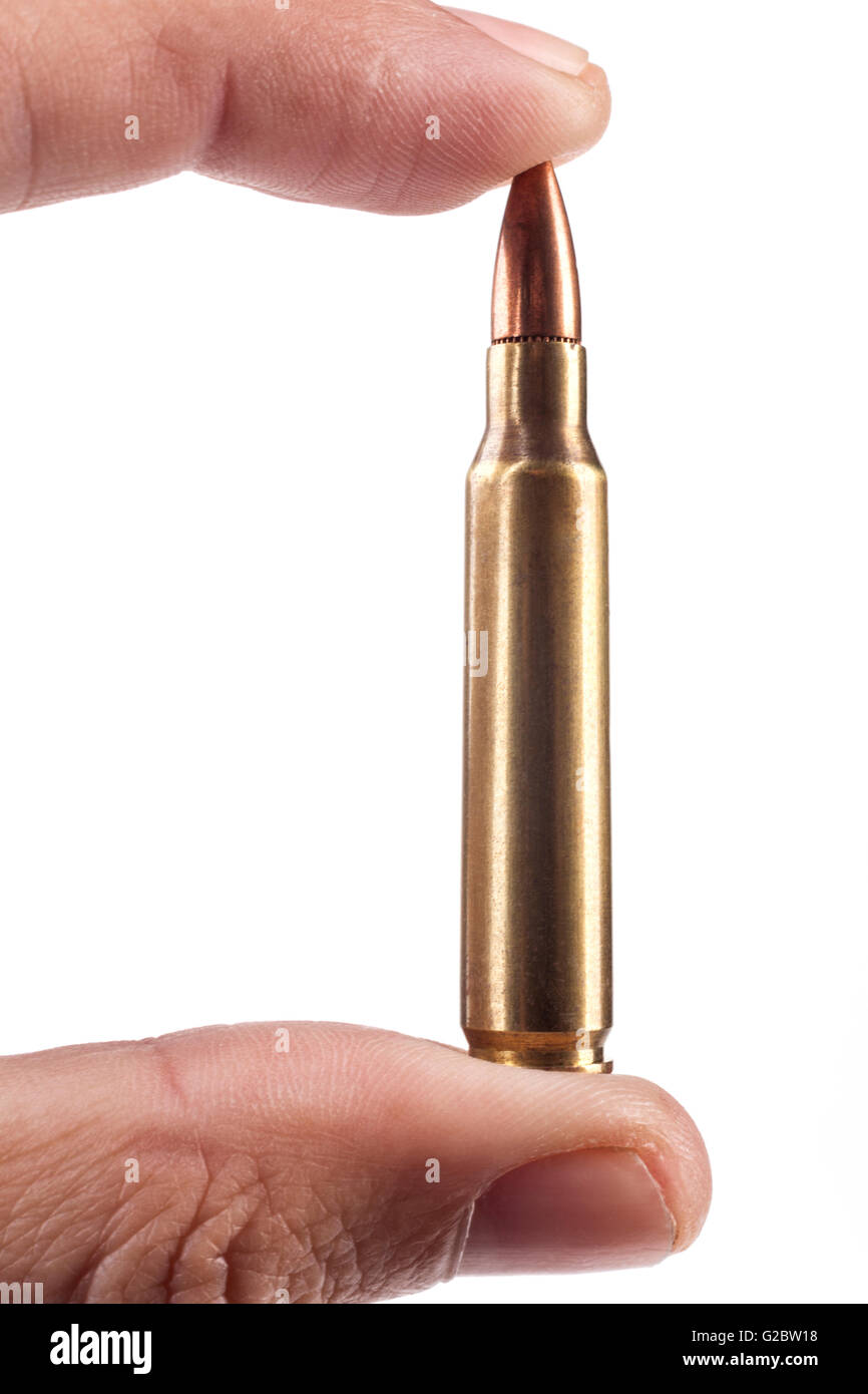 Fingers Holding Single Rifle Bullet Isolated On White Background Stock Photo