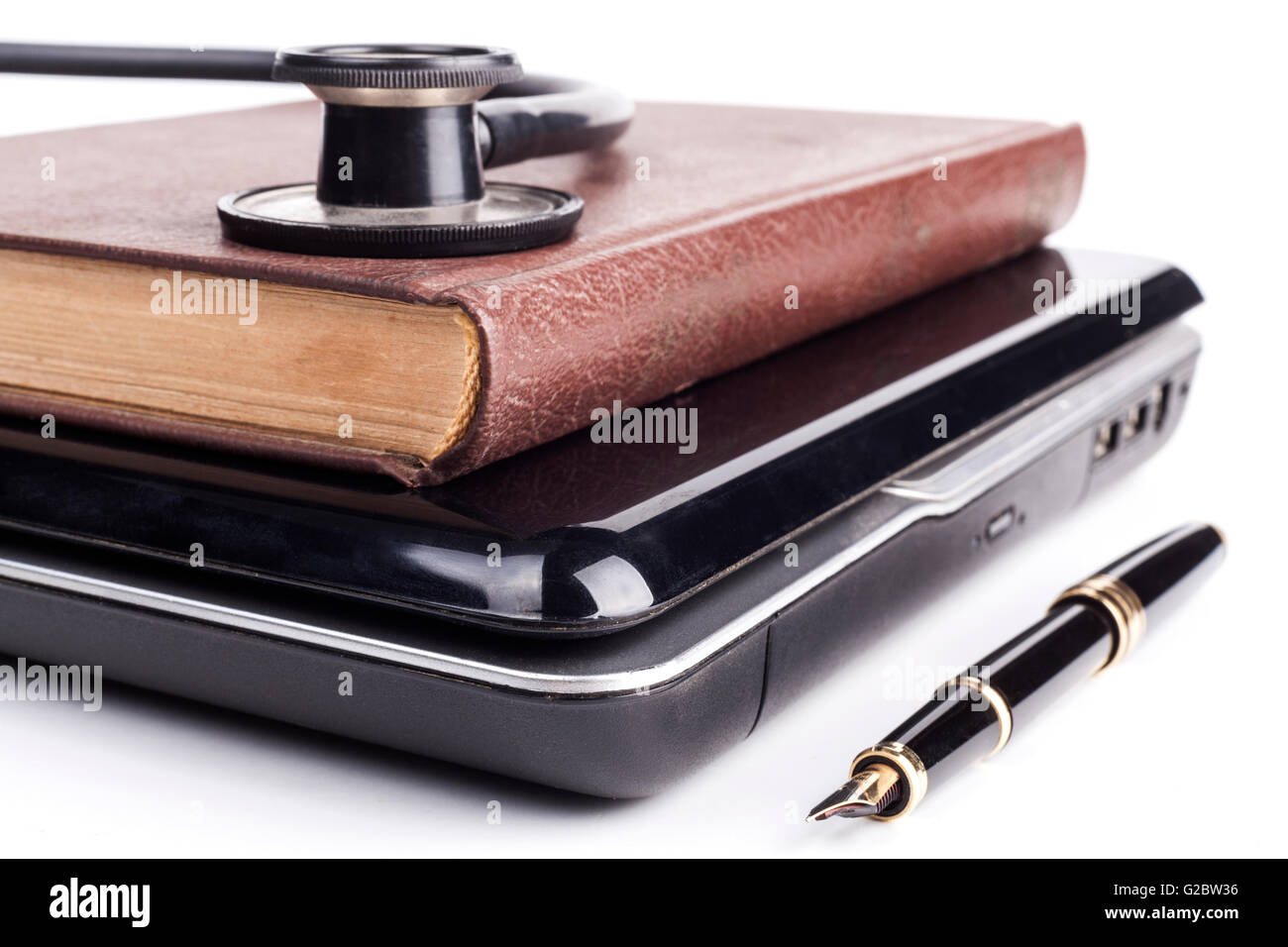 Old Book on black laptop isolated on white bakground Stock Photo