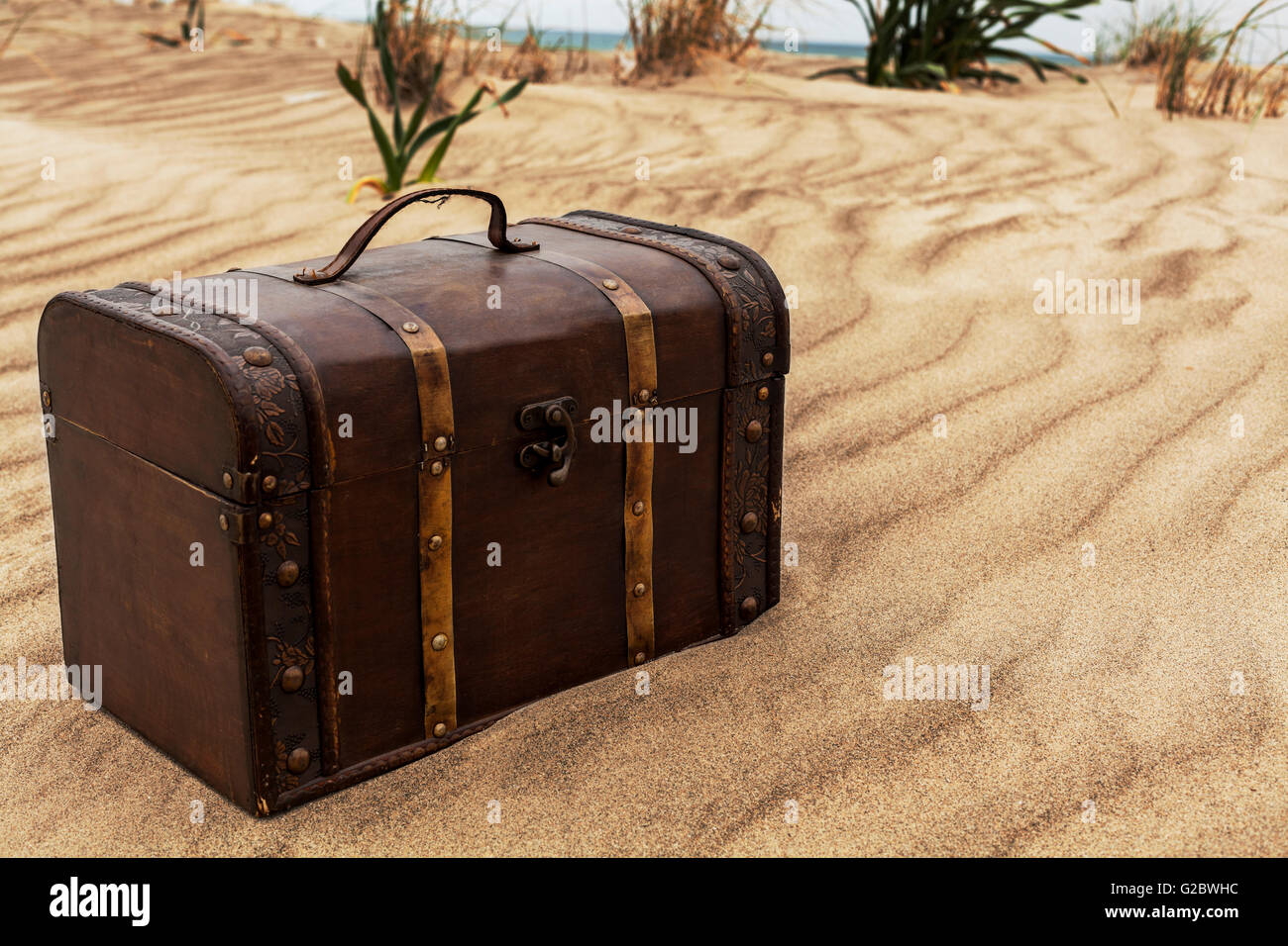 Treasure chest in sand dunes on the beach Stock Photo Alamy