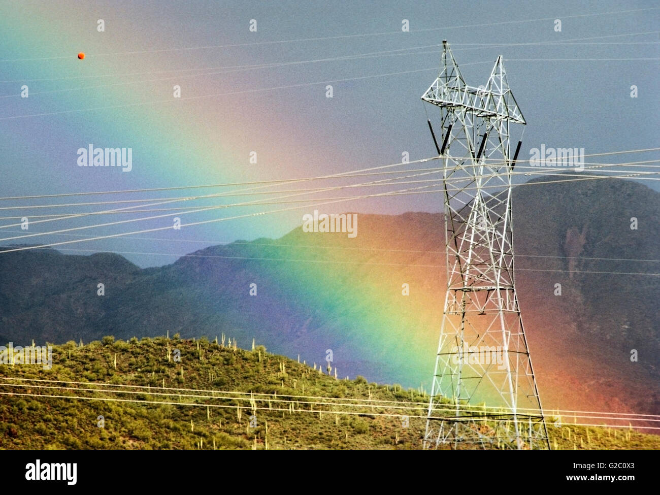 Electrical transmission lines and towers with a vivid, dramatic rainbow in the desert north of Phoenix, Arizona, USA Stock Photo