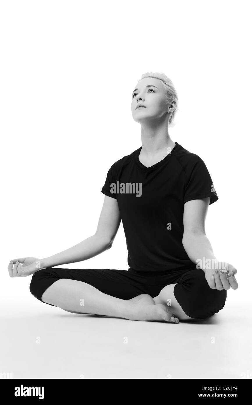 Woman sitting cross legged on floor Black and White Stock Photos