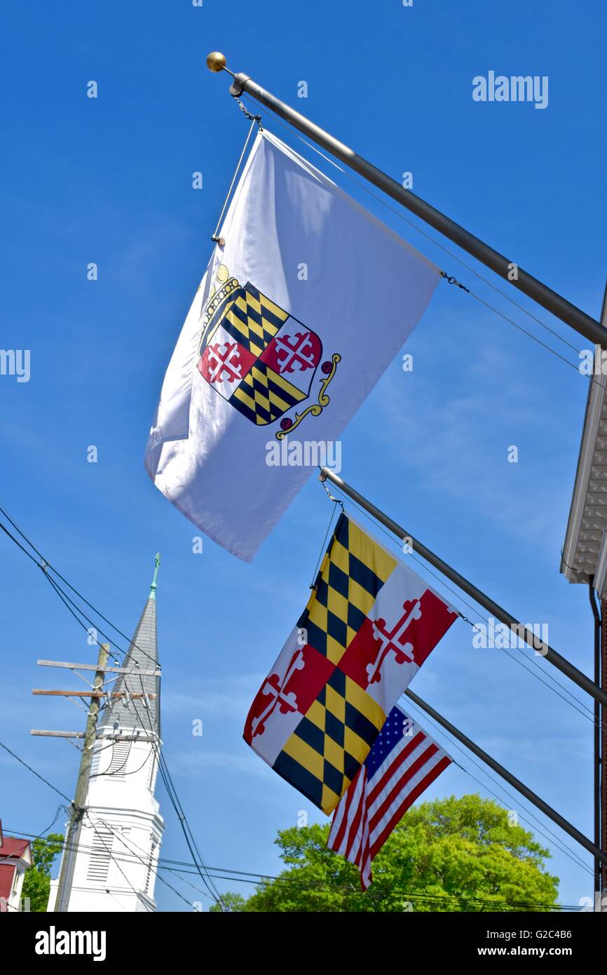 A Maryland state flag next to a USA flag hanging from a building in