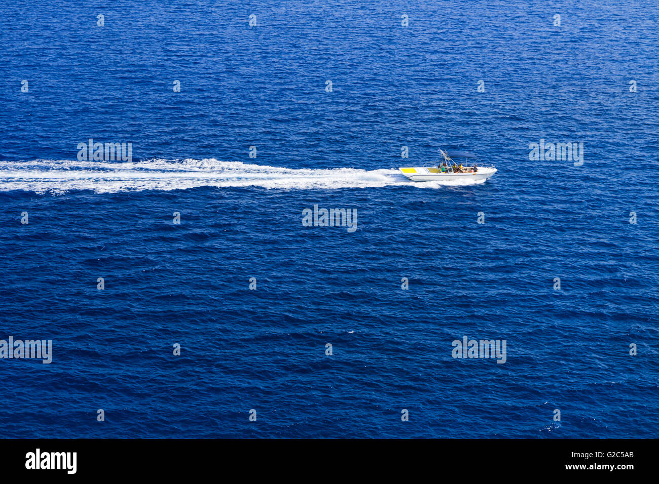 Kolymbia beach with the rocky coast in Greece. Motorboat and speed  in blue sea. Stock Photo