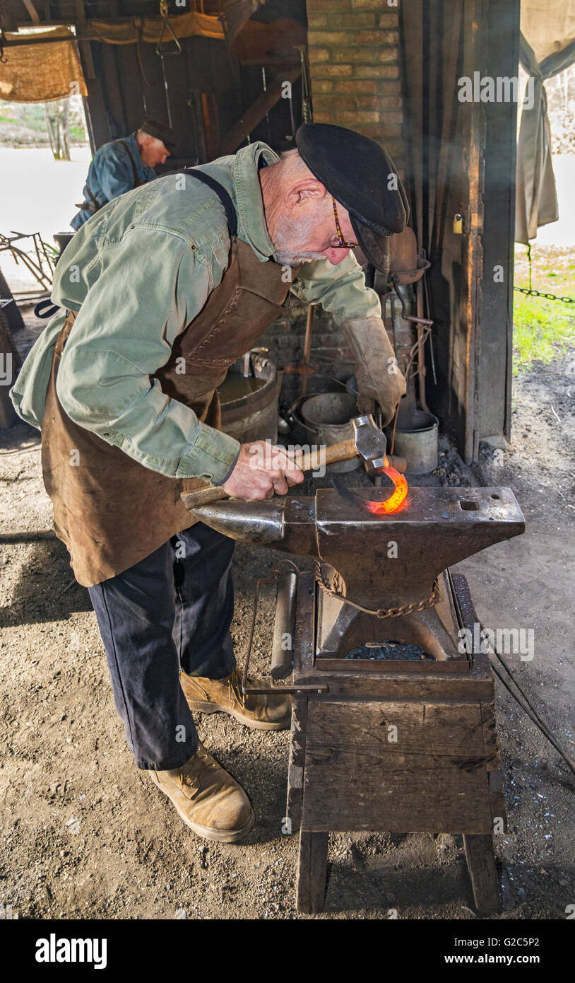 California, Coloma, Marshall Gold Discovery State Historic Park, blacksmith hammering red hot horseshoe on anvil Stock Photo