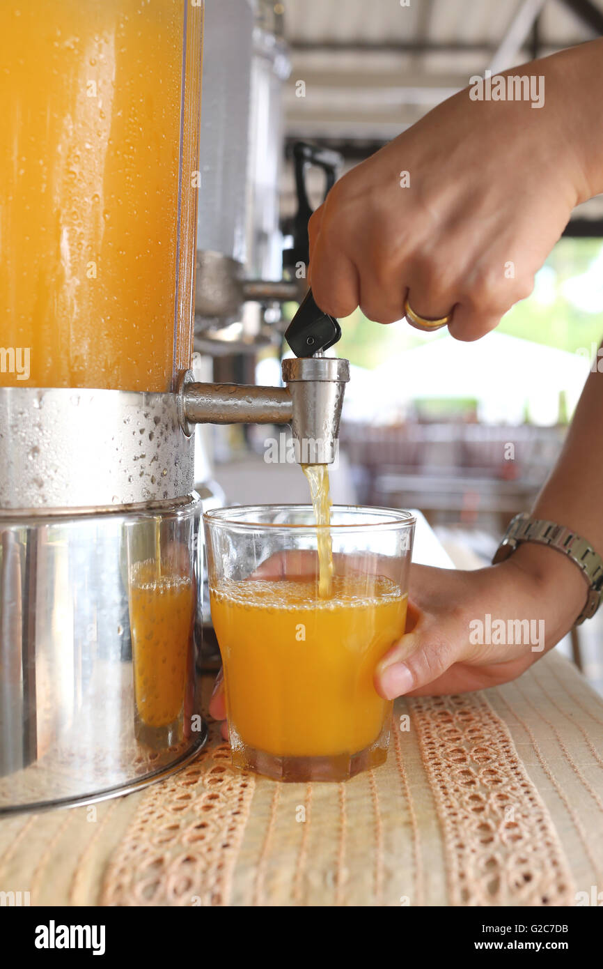woman's hands were pressing orange juice into drink glass in a restaurant. Stock Photo