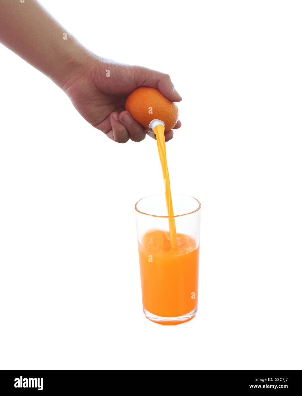 fresh orange in hand and have fruit juice flowing into a glass on white background for concept of healthy eating. Stock Photo