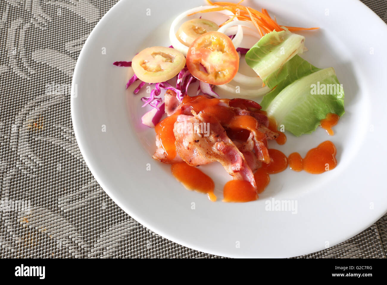Vegetable salads and spicy sauce in a white dish on food table. Stock Photo