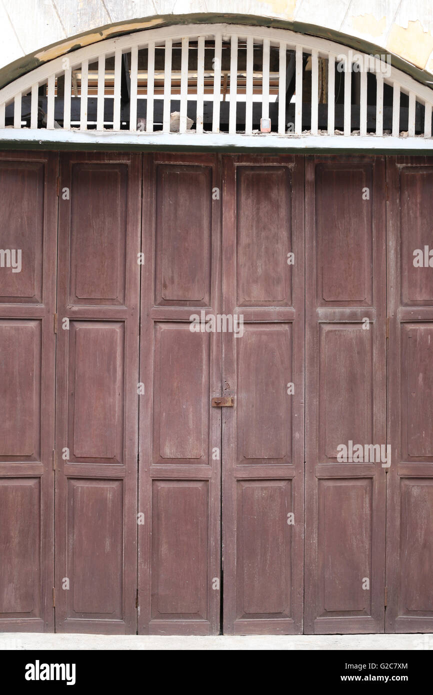 vintage old wooden door and have weathered in the Thailand community. Stock Photo