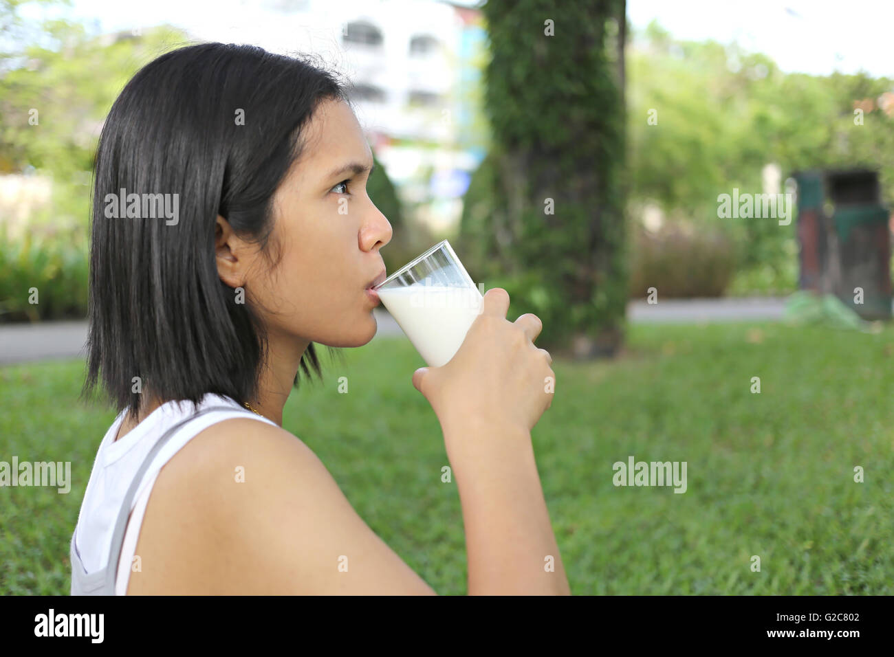 Asia pregnant mom was drinking milk in the garden for good health. Stock Photo