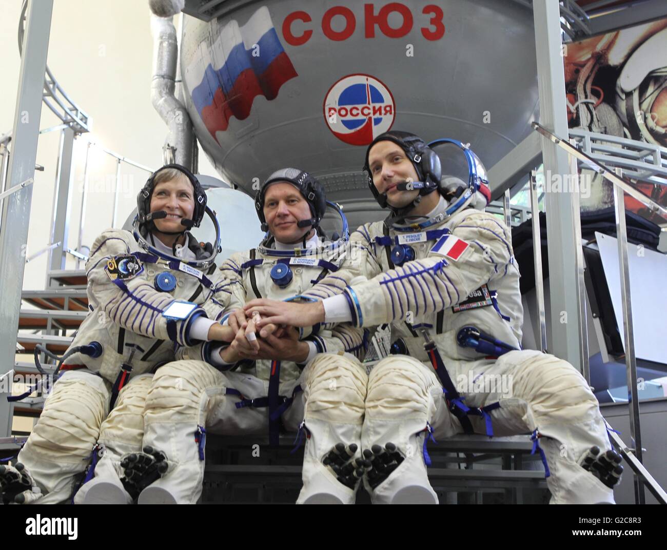 International Space Station Expedition 48 backup crew pose for photos at the Soyuz simulator in launch suits at the Gagarin Cosmonaut Training Center May 26, 2016 in Star City. Russia, Crewmembers from L-R are: NASA astronaut Peggy Whitson, Russian cosmonaut Oleg Novitskiy and French astronaut Thomas Pesquet. Stock Photo