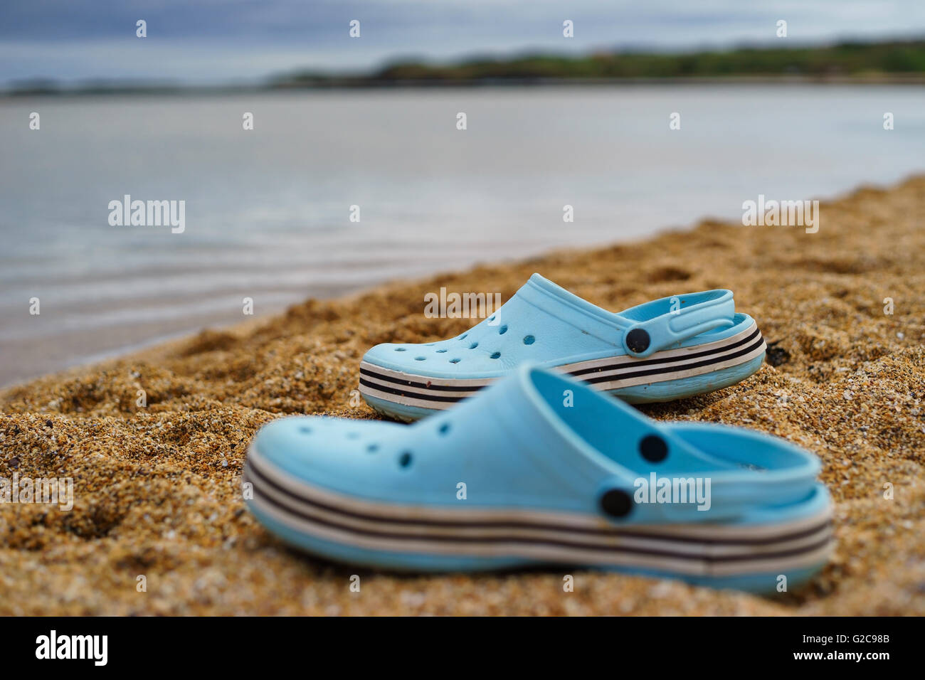 Blue shoes on sandy beach Stock Photo