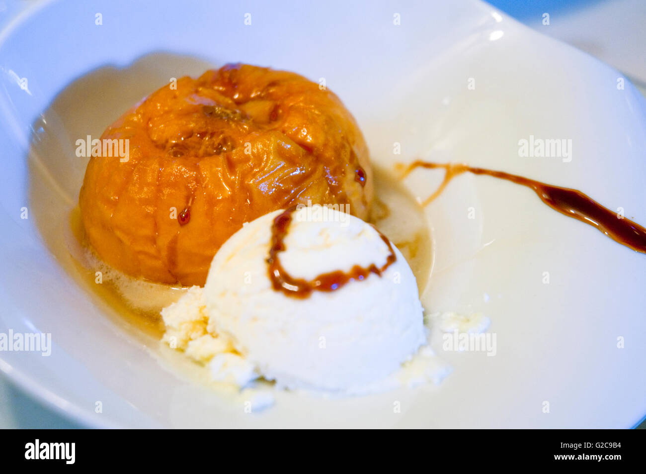 Dessert: baked peach with cheese ice cream. Close view. Stock Photo