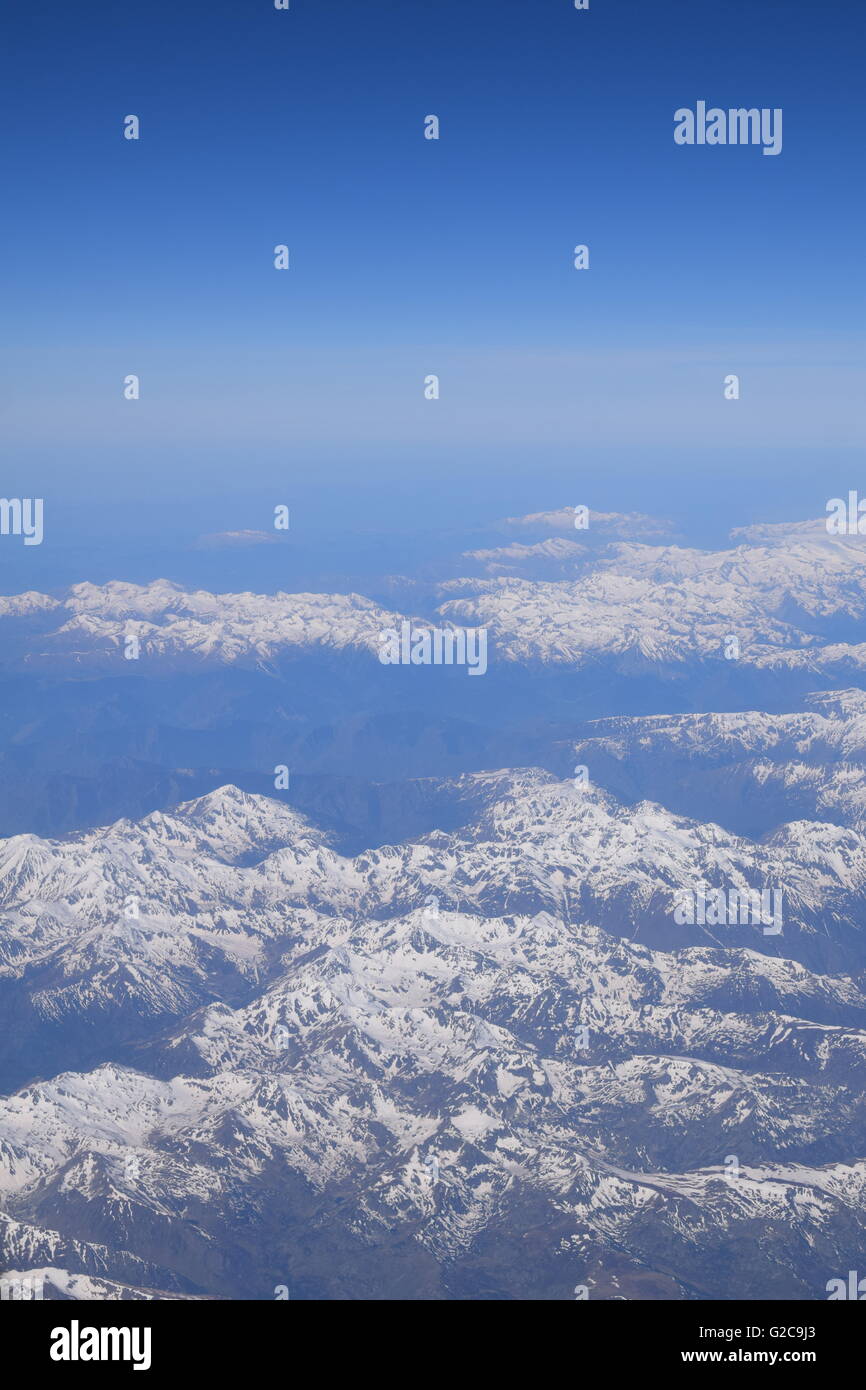 View of snow covered The Alps mountain range from airplane window Stock Photo