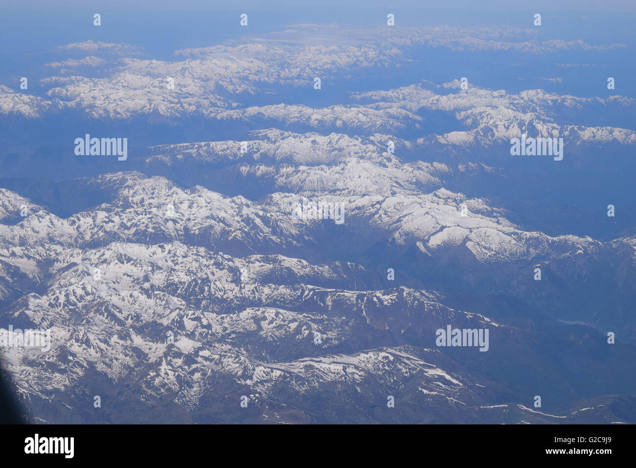 View of snow covered The Alps mountain range from airplane window Stock Photo