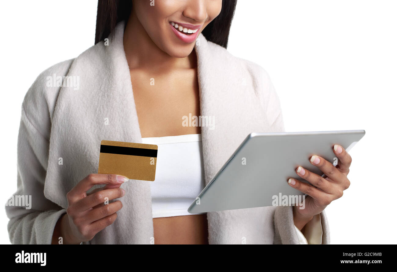 Mulatto black woman holding digital tablet computer and pay from gold credit card. Close-up view. Isolated on white. Stock Photo