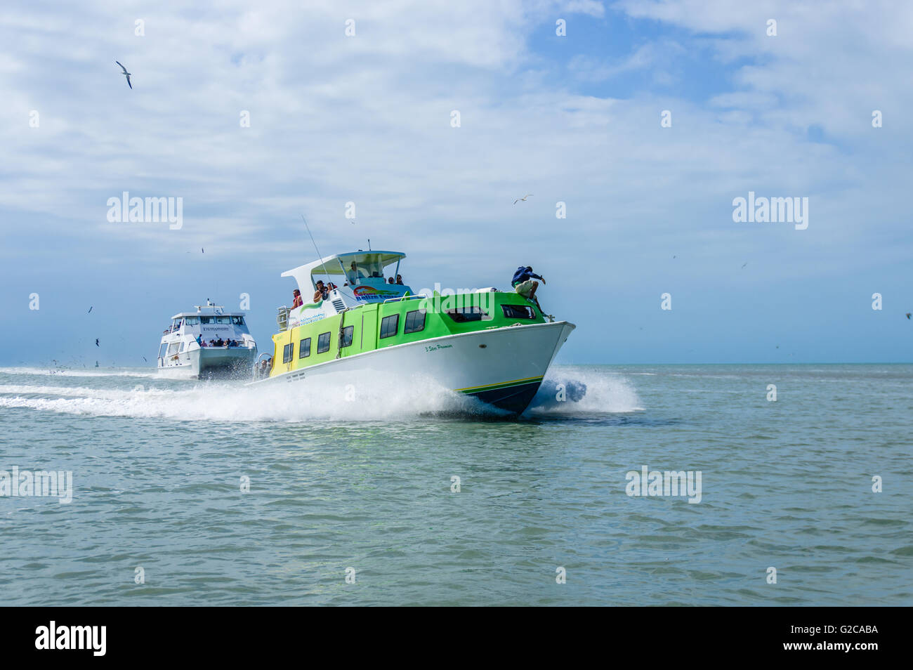 Shuttle boats transport tourists from a cruise ship to the port dock.  Belize City, Belize Stock Photo