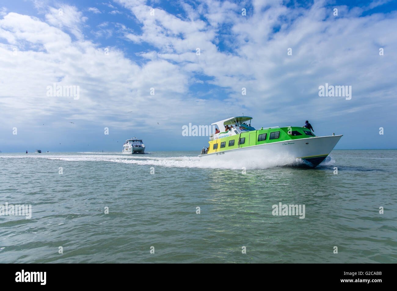 Shuttle boats transport tourists from a cruise ship to the port dock.  Belize City, Belize Stock Photo
