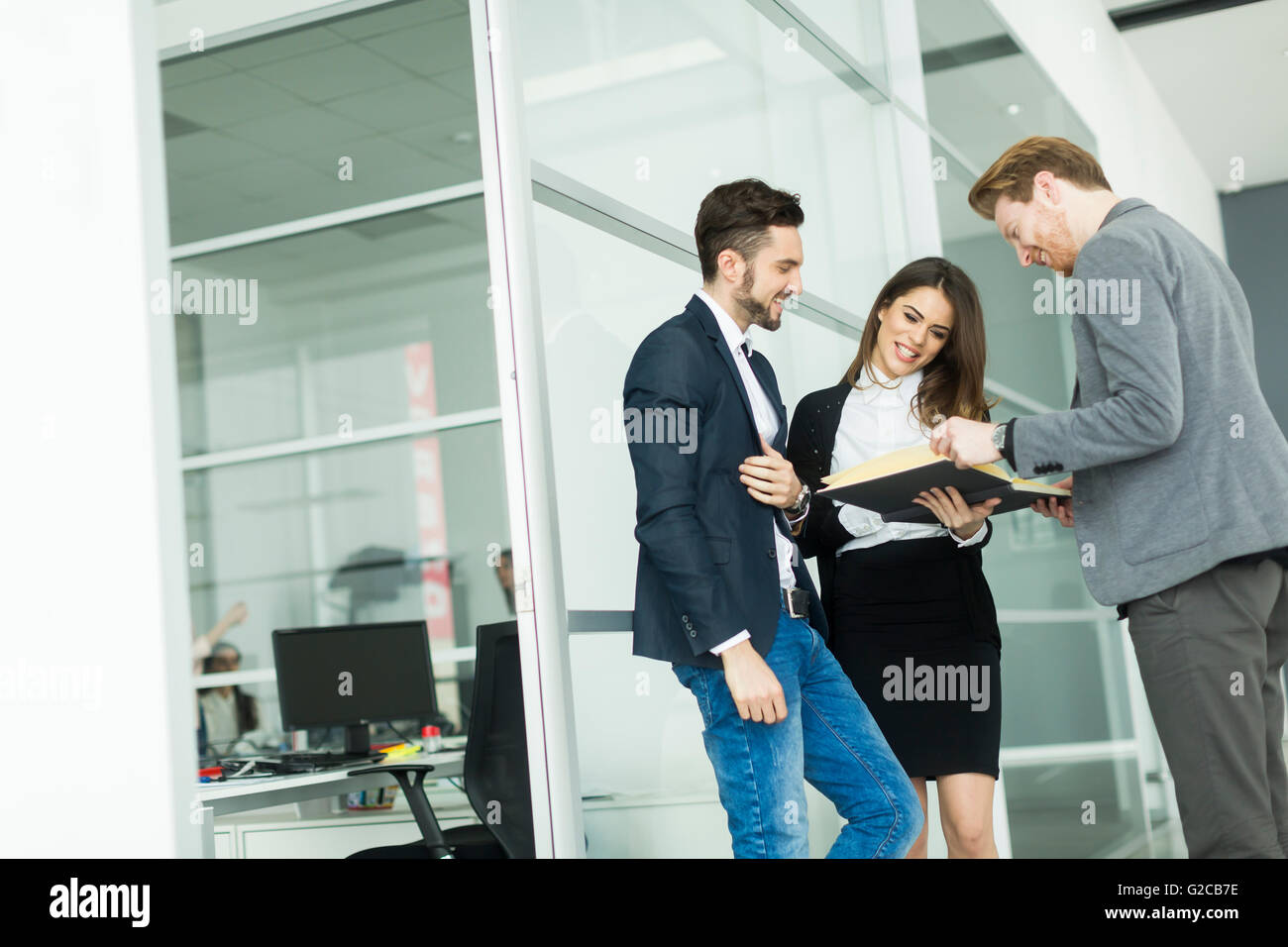 Young business people standing in the office Stock Photo - Alamy