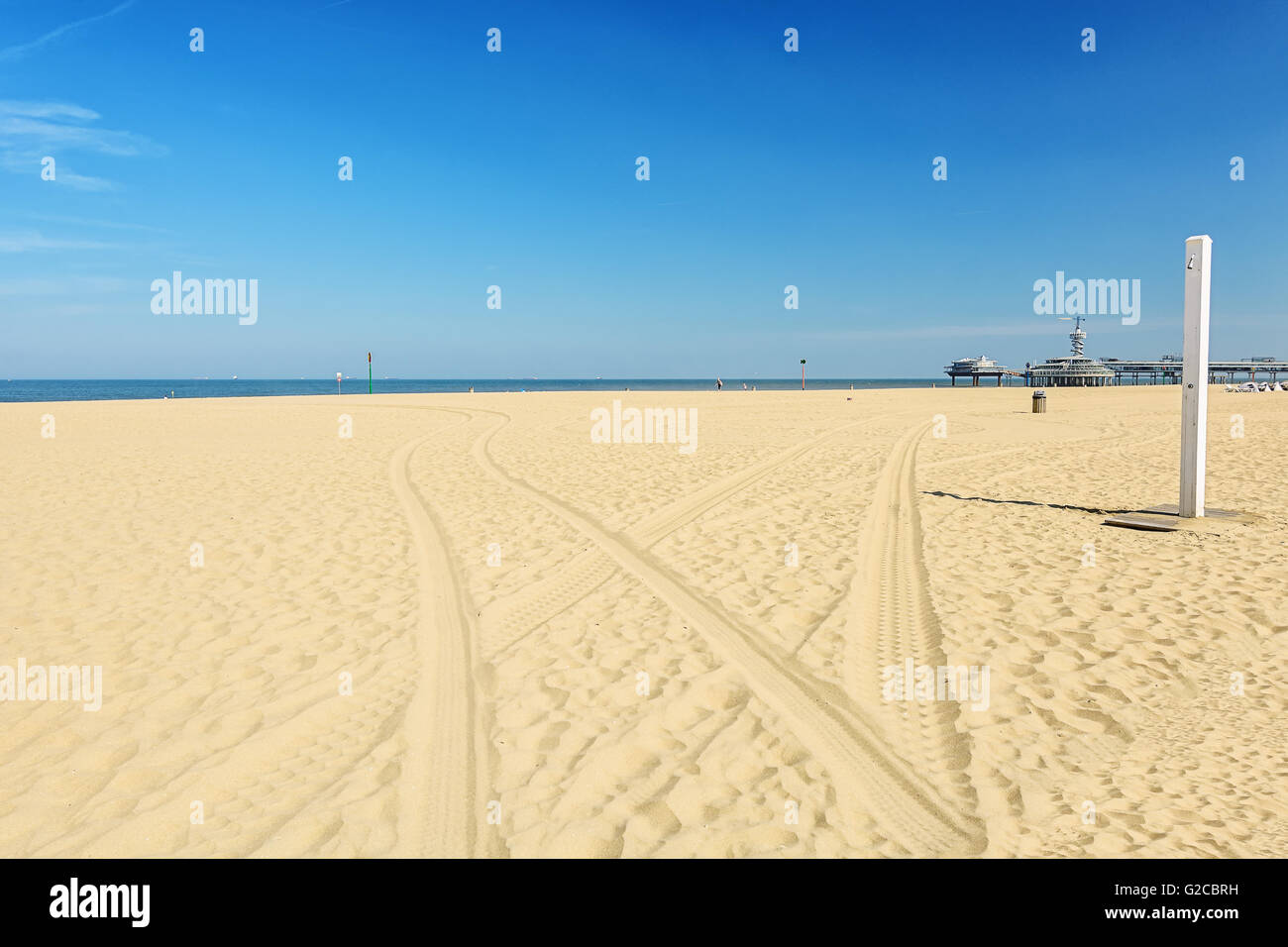 Traces from the car on the sand leading to the sea. Stock Photo