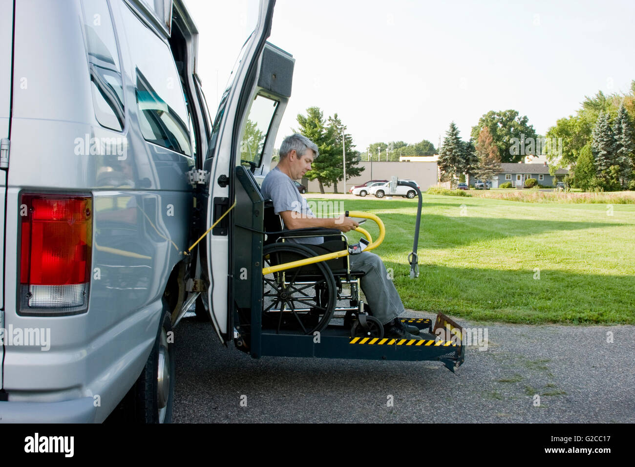 disability conversion lift van with a man in a wheelchair on the gate Stock Photo