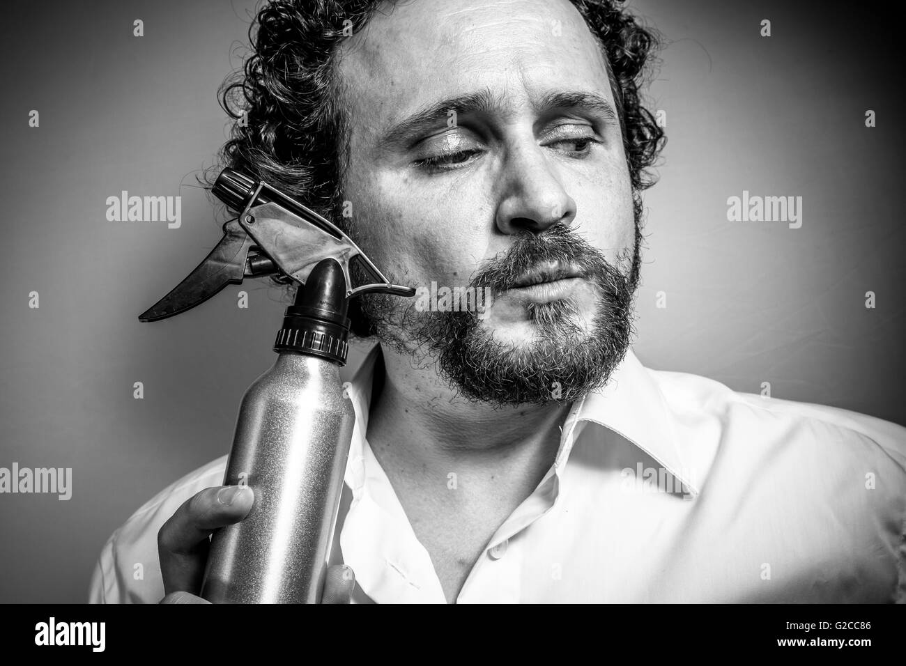 cleaning spray, man with intense expression, white shirt Stock Photo