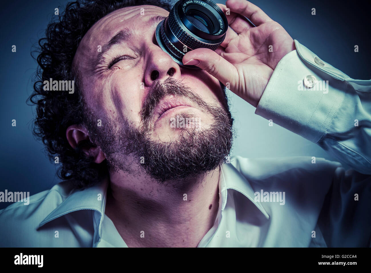 photographer with lens, man with intense expression, white shirt Stock
