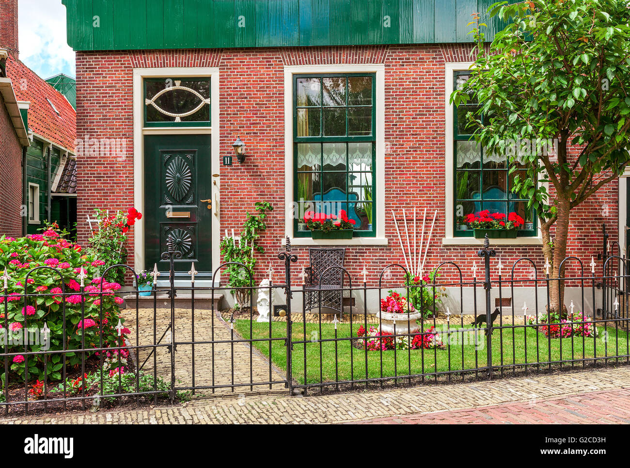 Facade of typical dutch house with small garden and flowers in Zaanse Scans, Netherlands. Stock Photo