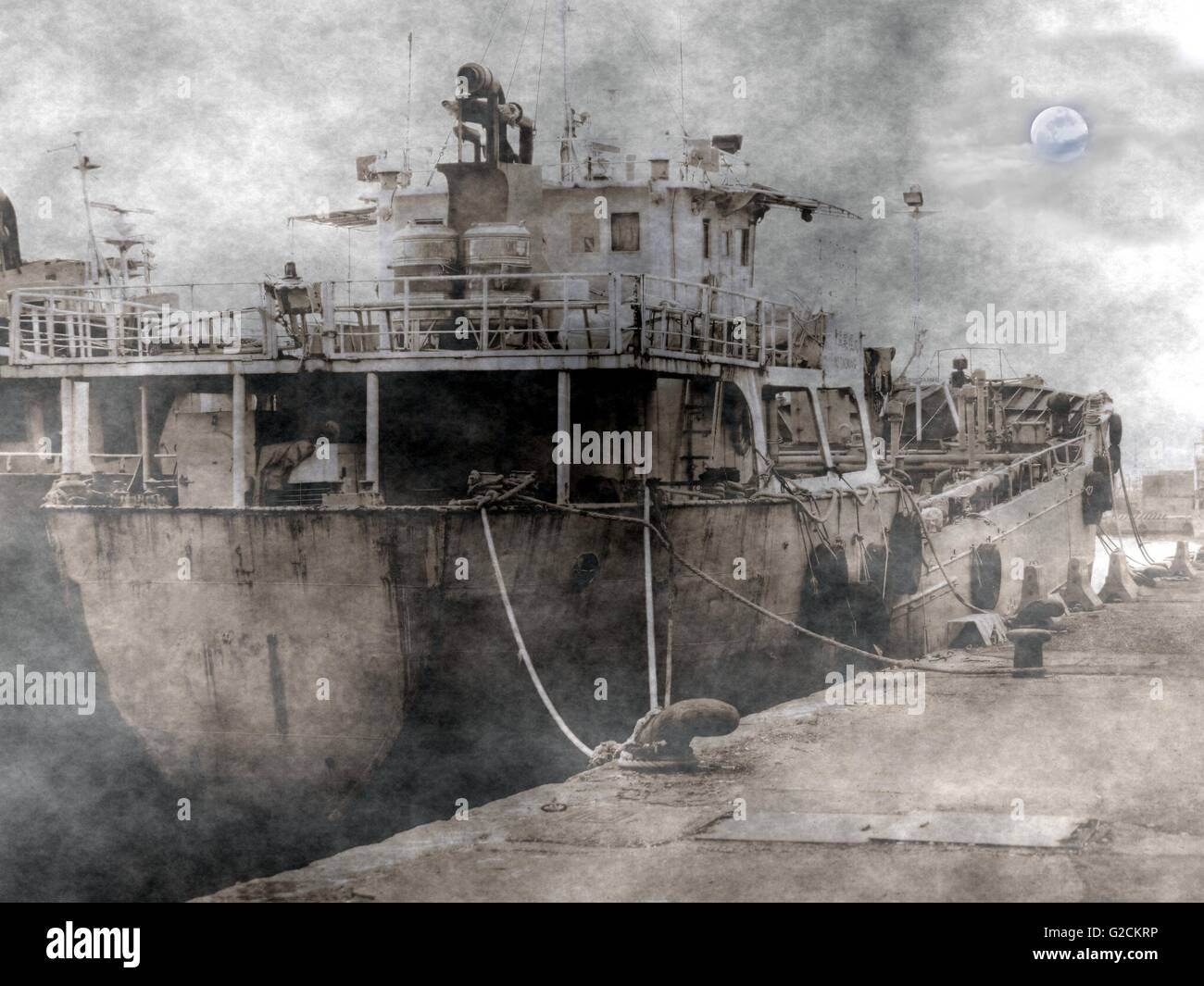 A spooky scene of an old dilapidated ship amidst fog, smoke and a sinister moon Stock Photo